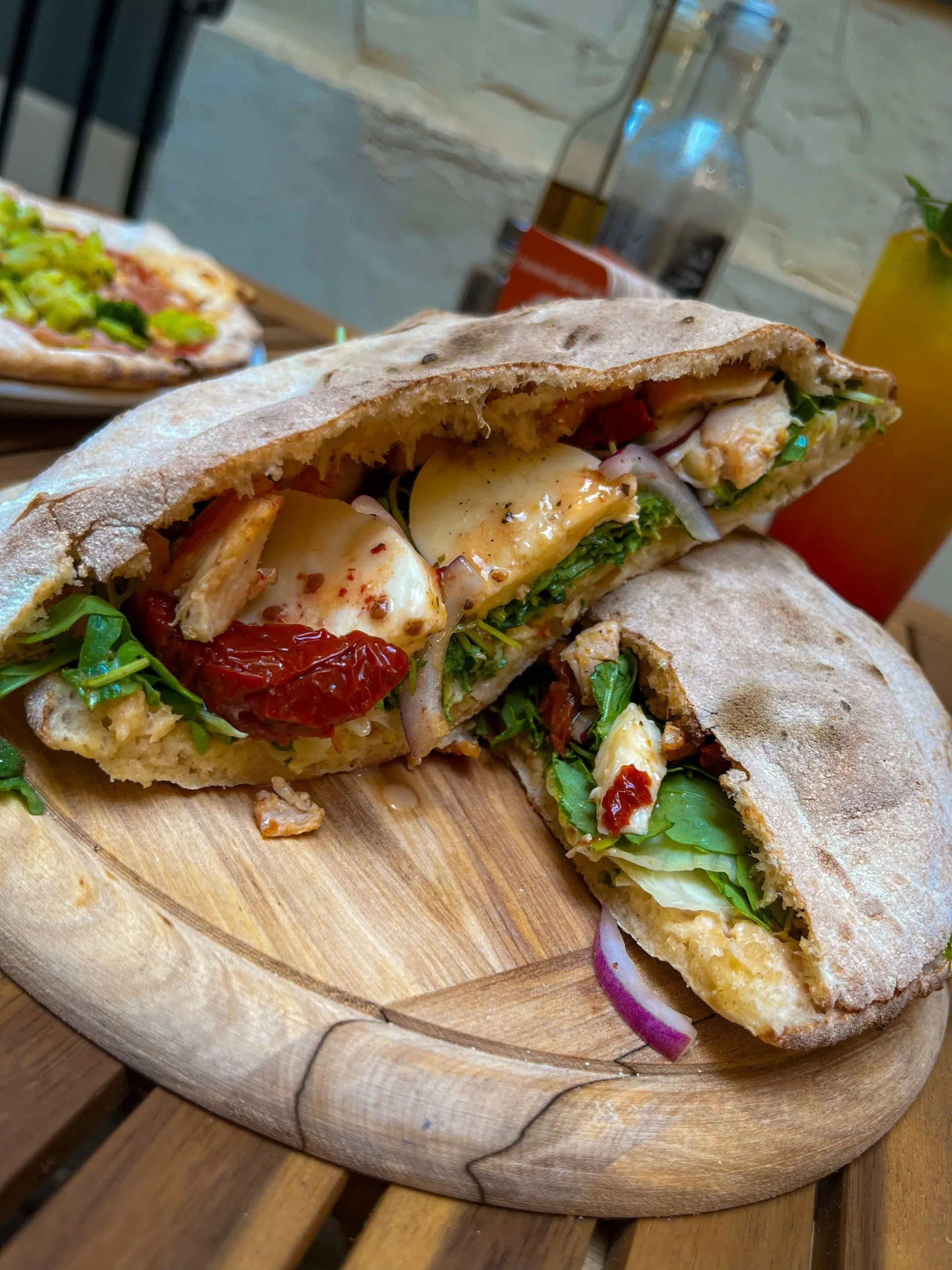 Calzone – talianska obrátená pizza – Plnená pizzová kapsa s kuracím mäsom, mozzarellou, sušenými paradajkami, rukolou a červenou cibuľou. Pizzeria Passage Košice