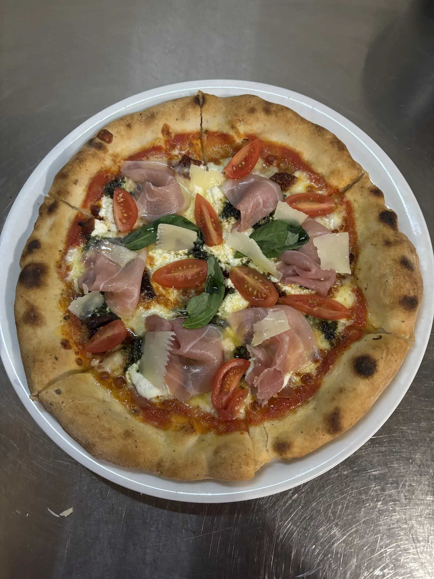 Pizza s prosciuttom a bazalkou – Klasická pizza s parmskou šunkou, cherry paradajkami, bazalkou a parmezánom. Pizzeria Passage Košice