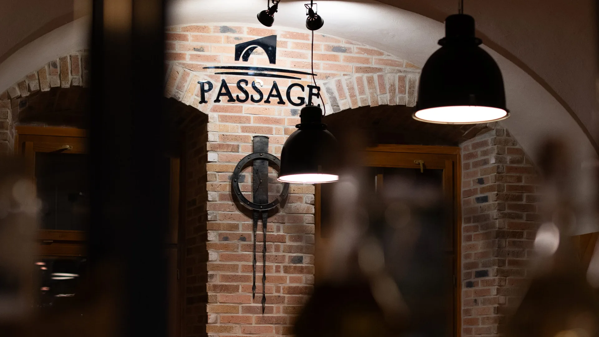 Interiér Pizzerie Passage s tehlovou klenbou a logo PASSAGE